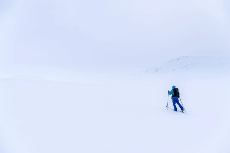 Man på längdskidor i bergen nära Hovringen i Rondane nationalpark, Norge